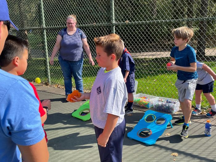 A group of young boys are playing a game on a tennis court.