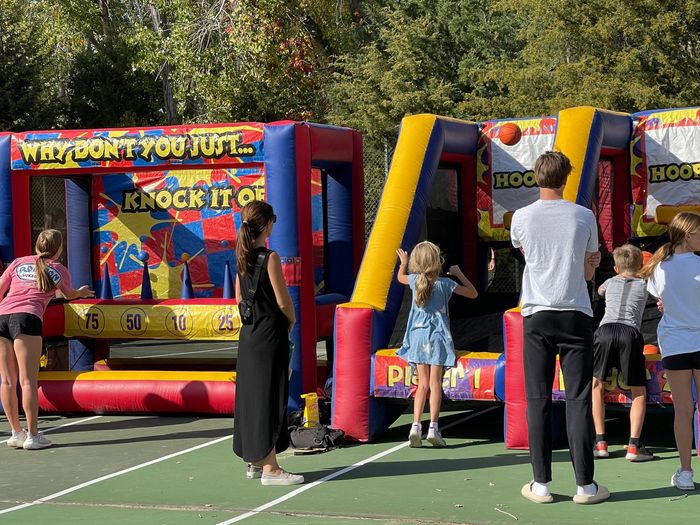 A group of people are standing in front of a bouncy house.