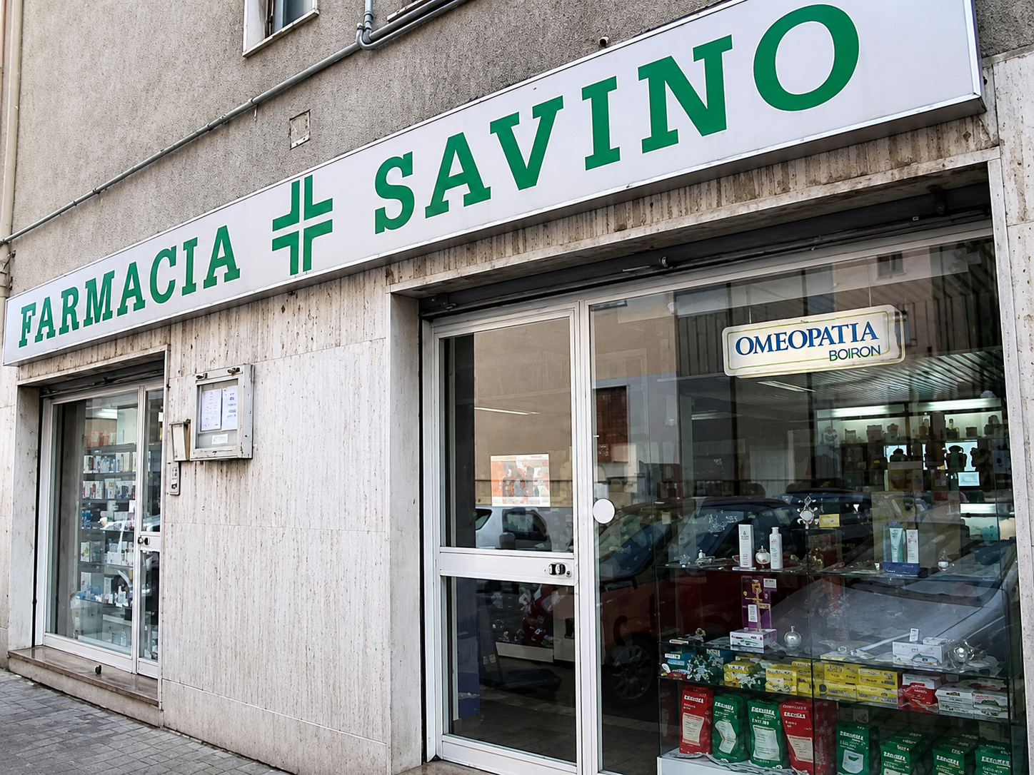 Esterno della farmacia Savino con insegna verde e ingresso in vetro.
