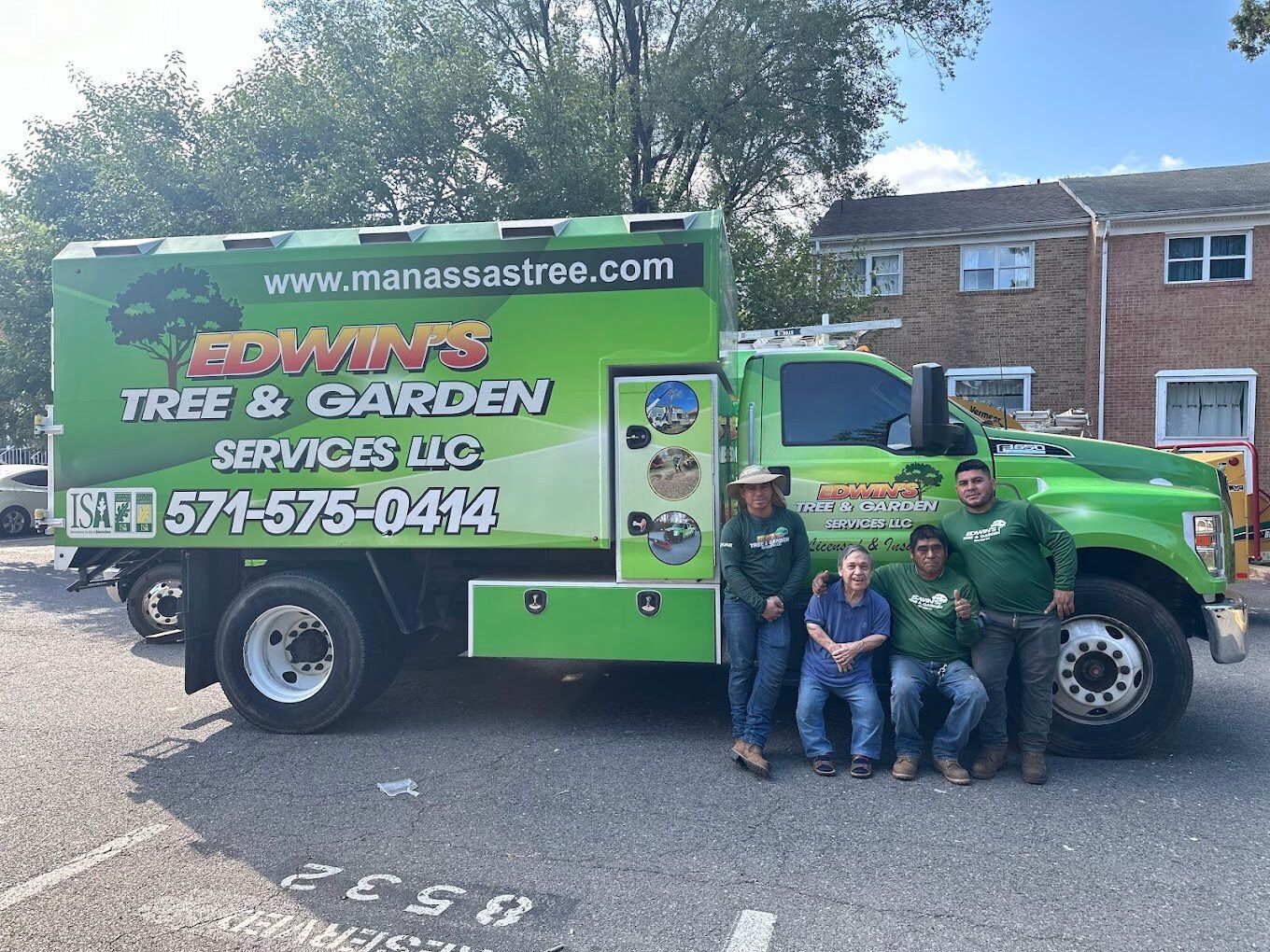 Team posing in front of a green truck with 