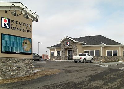 Reuter Family Dentistry building with sign, a white truck, and a light-colored exterior.