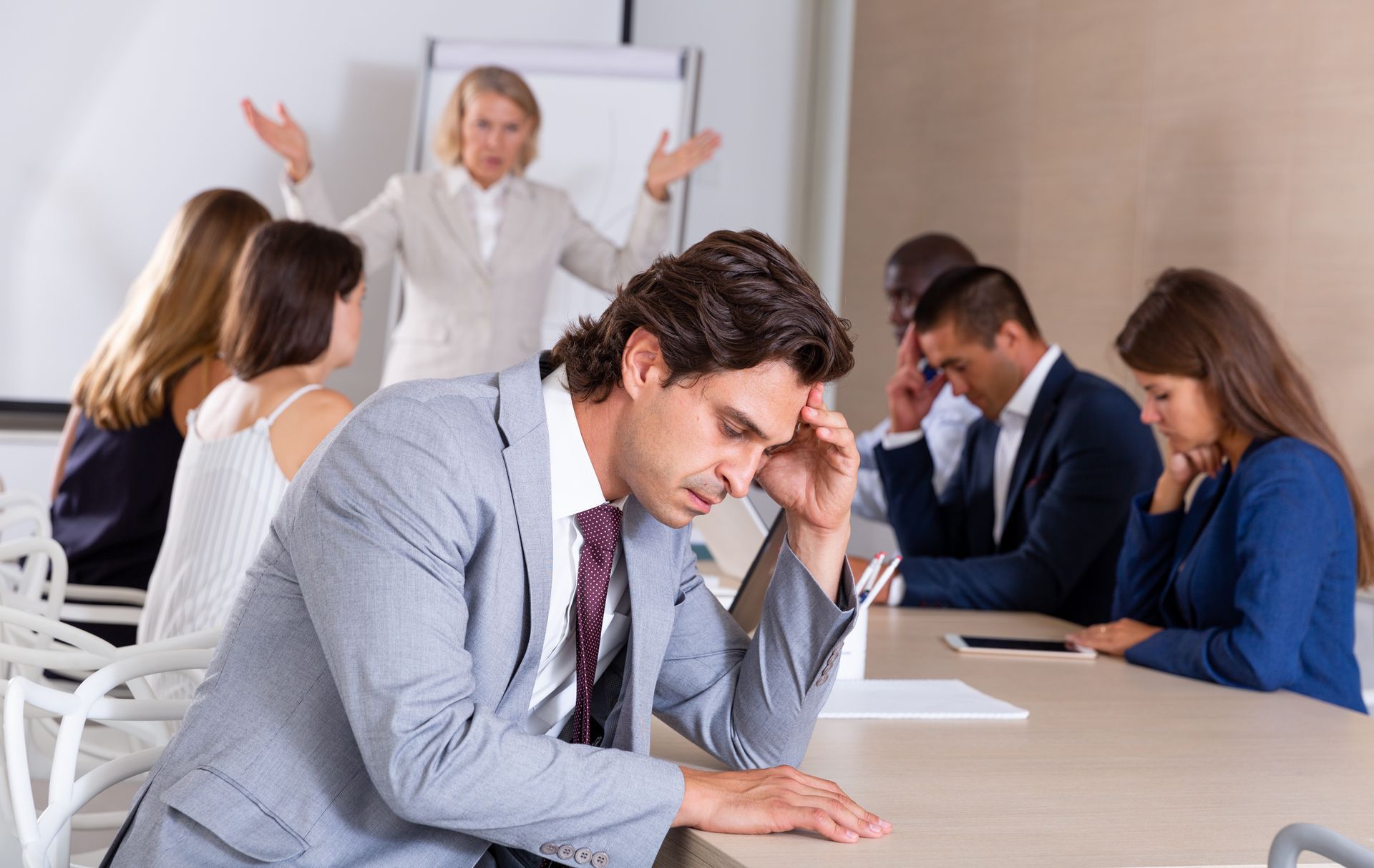 A Stressed Person Sits at a Desk During a Meeting — Australian Employee Lawyers in Broadbeach Waters, QLD