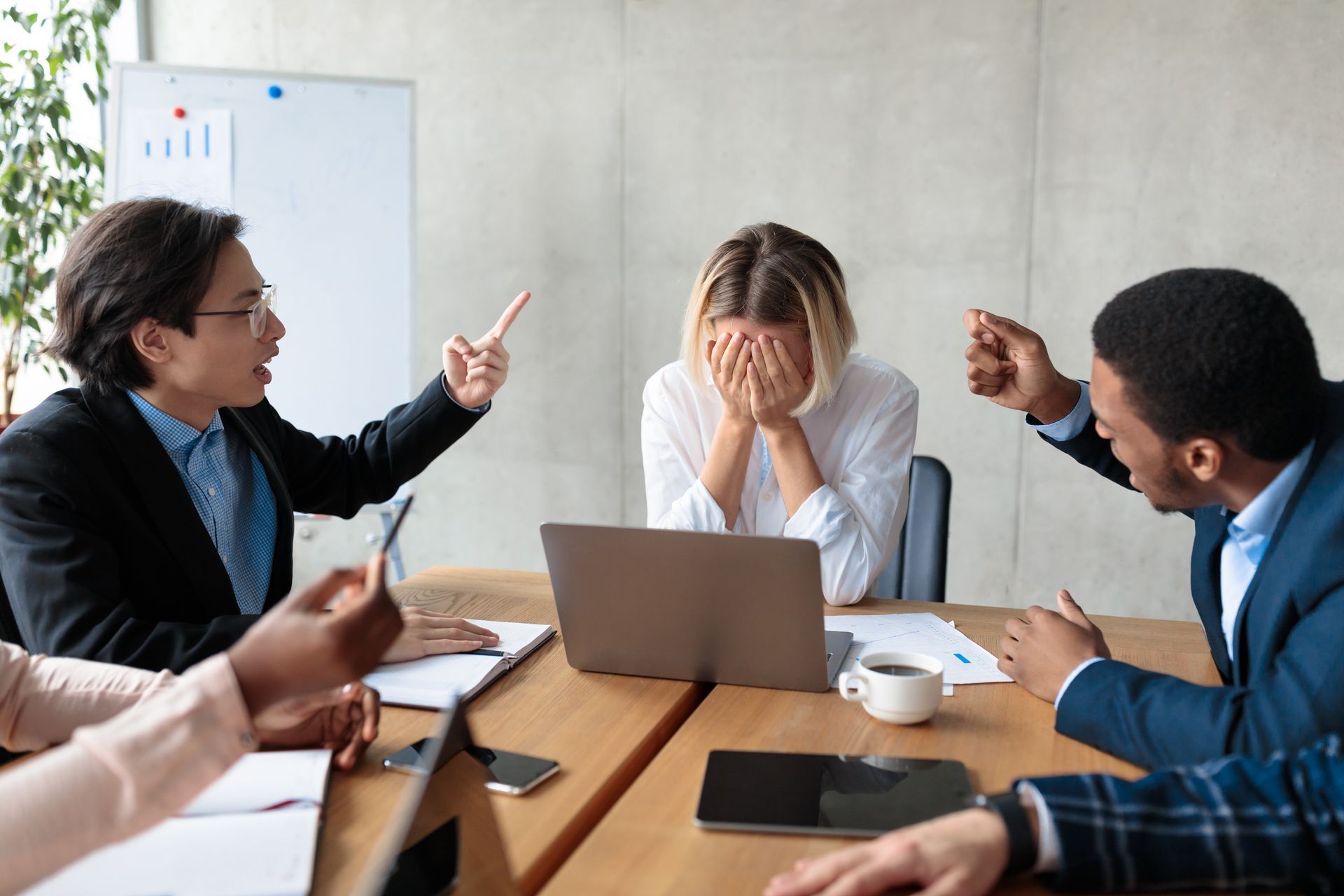 Employee Sits While Two Coworkers Point at Them in an Office Setting — Australian Employee Lawyers in Sunshine Coast, QLD