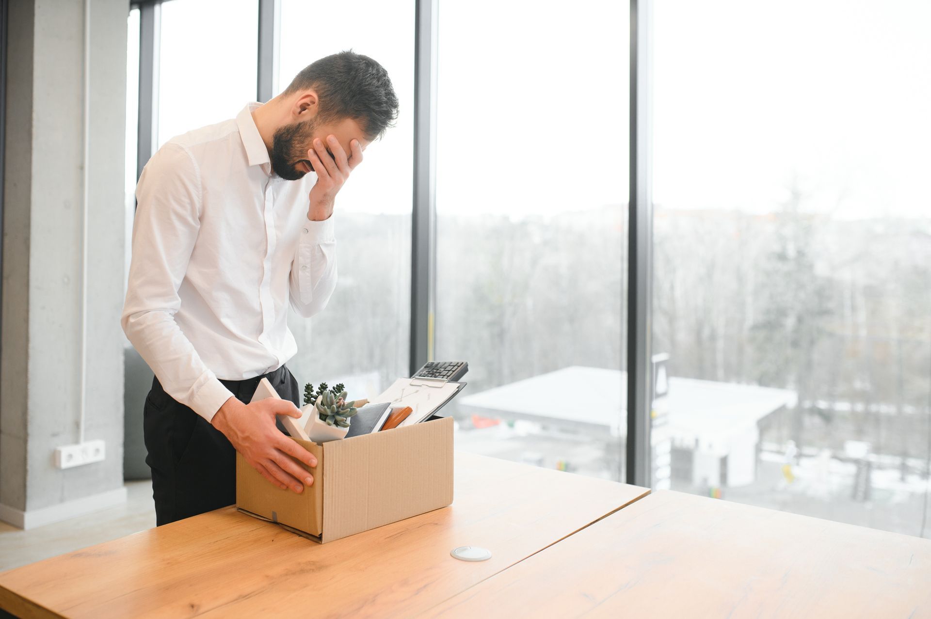 Employee Stands by a Desk, Looking Distressed — Australian Employee Lawyers in Broadbeach Waters, QLD