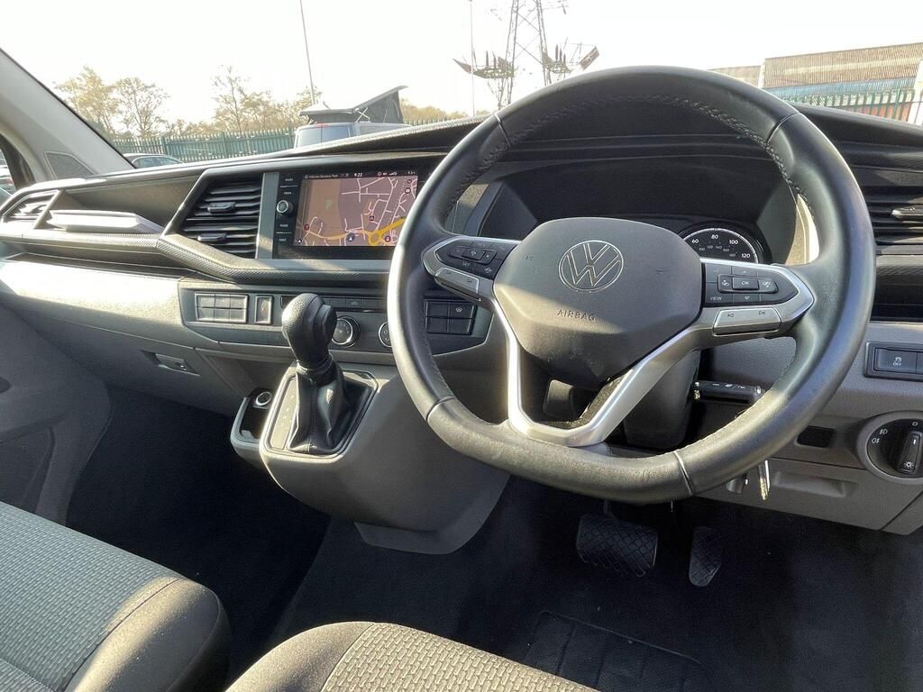 Car interior with right-hand steering wheel, manual gear shift, and dashboard display.