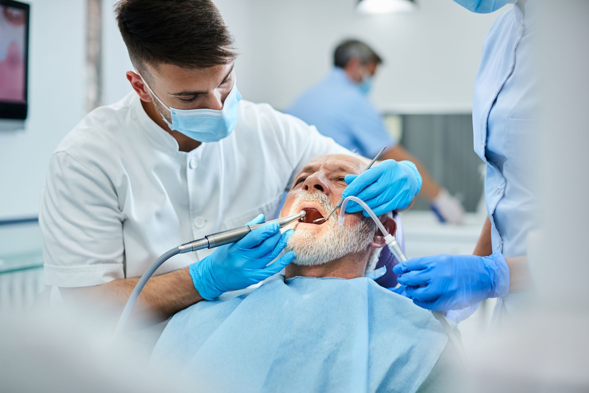 Dentist and dental assistant performing an oral examination on a patient in a dental clinic.