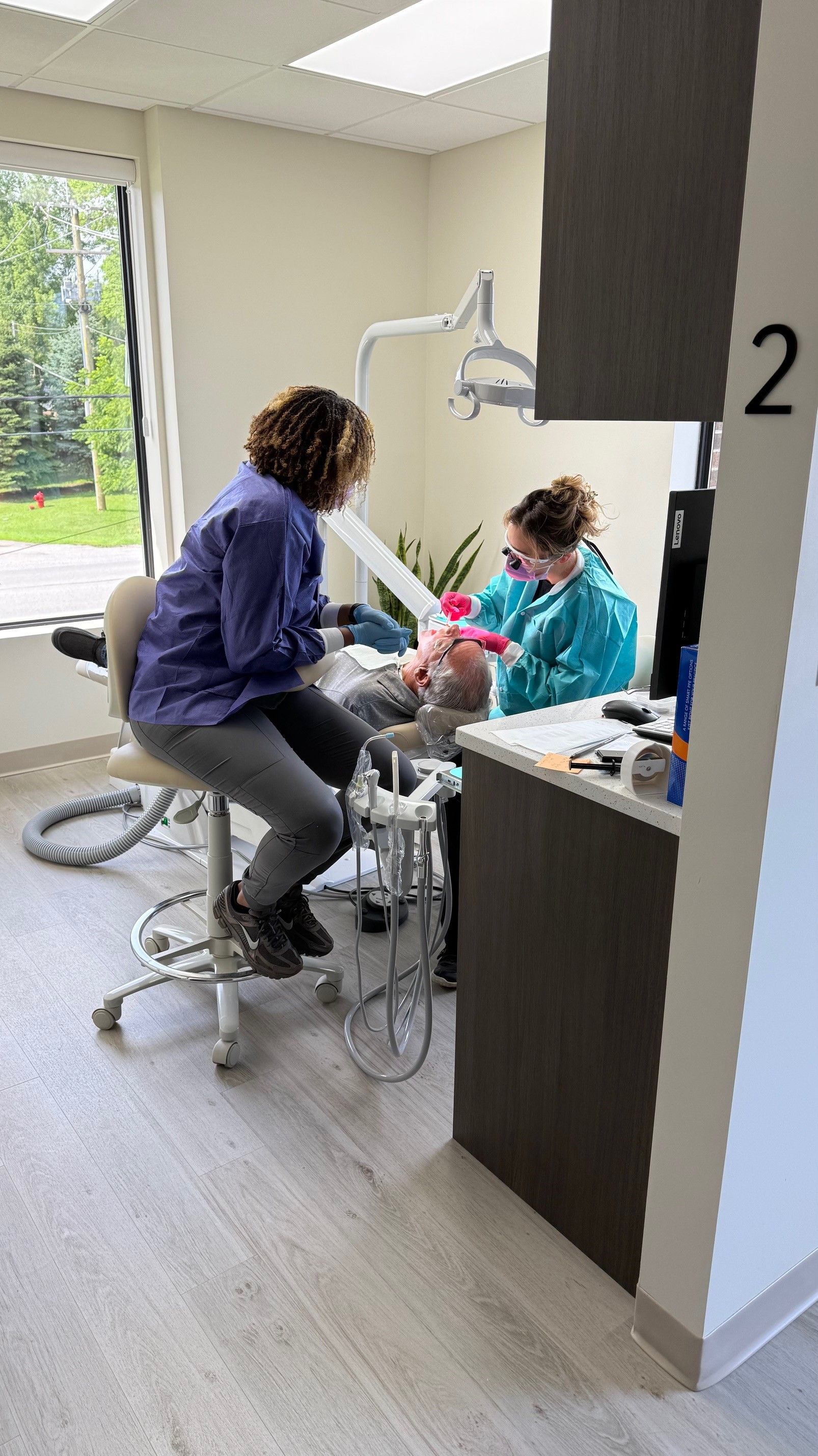 Dentist and assistant working on a patient in a dental office.