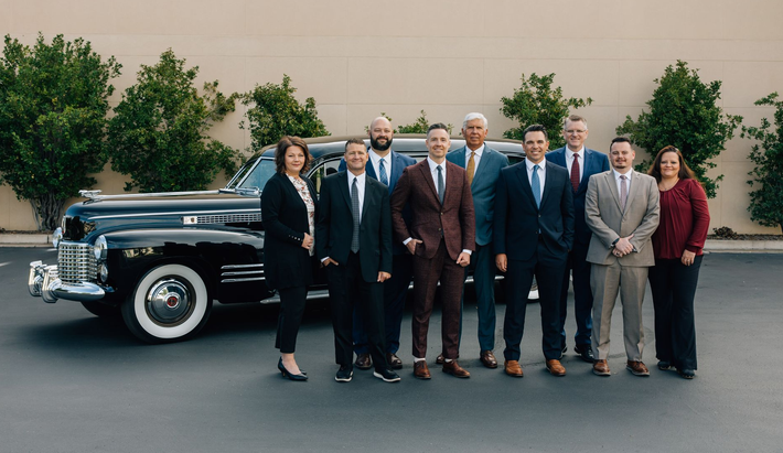Allen Mortuary staff with hearse in parking lot in Logan, UT
