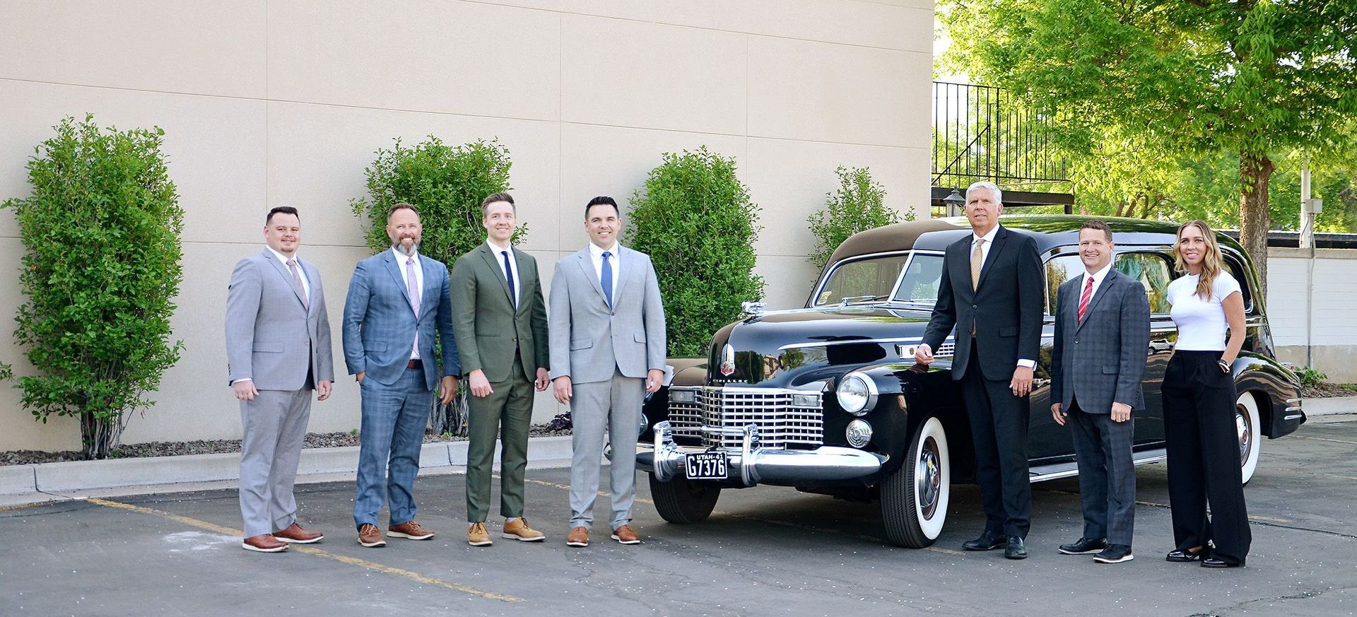 Staff members of Allen Mortuaries in front of hearse at facilities in Logan, UT 84321