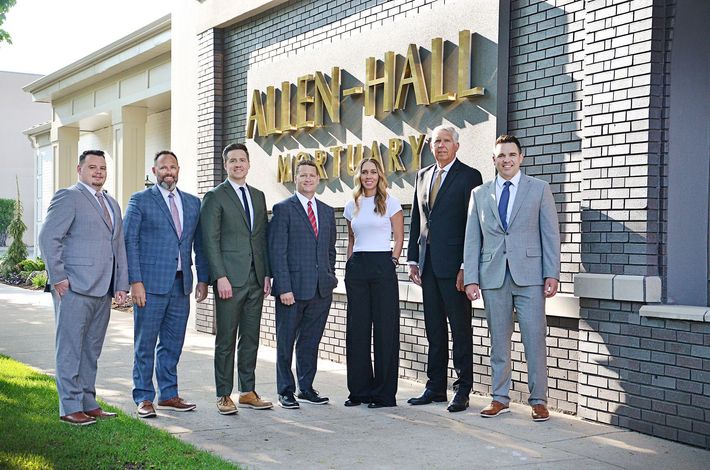 Allen Mortuary staff with hearse in parking lot in Logan, UT