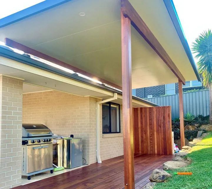 A Brick House With a Wooden Deck and a Grill — Better Built Patios & Decking in Wollongbar, NSW