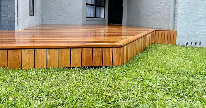 A Wooden Deck is Sitting on Top of a Lush Green Lawn — Better Built Patios & Decking in Wollongbar, NSW