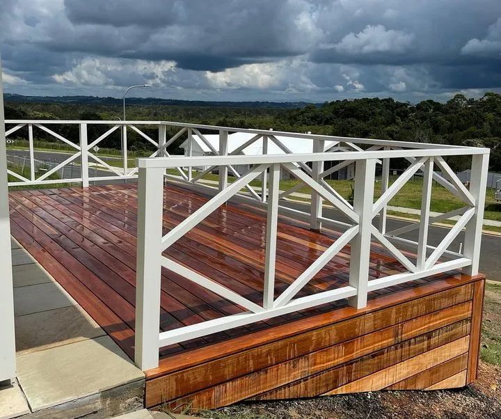 A Wooden Deck With a White Railing on a Cloudy Day — Better Built Patios & Decking in Wollongbar, NSW