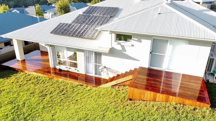 A White House With a Wooden Deck and Solar Panels on the Roof — Better Built Patios & Decking in Wollongbar, NSW