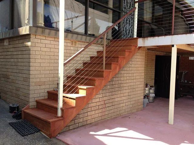 A Set of Stairs Leading Up to a Brick Building — Better Built Patios & Decking in Wollongbar, NSW