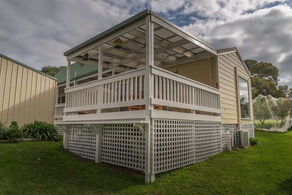 A Small House With a Porch and a Fence in the Backyard — Better Built Patios & Decking in Lismore, NSW