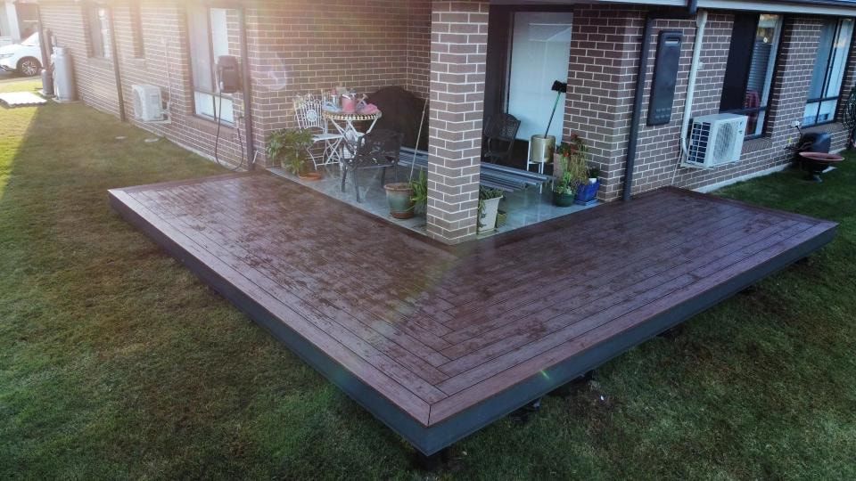A Brick House With a Wooden Deck in Front of It — Better Built Patios & Decking in Wollongbar, NSW