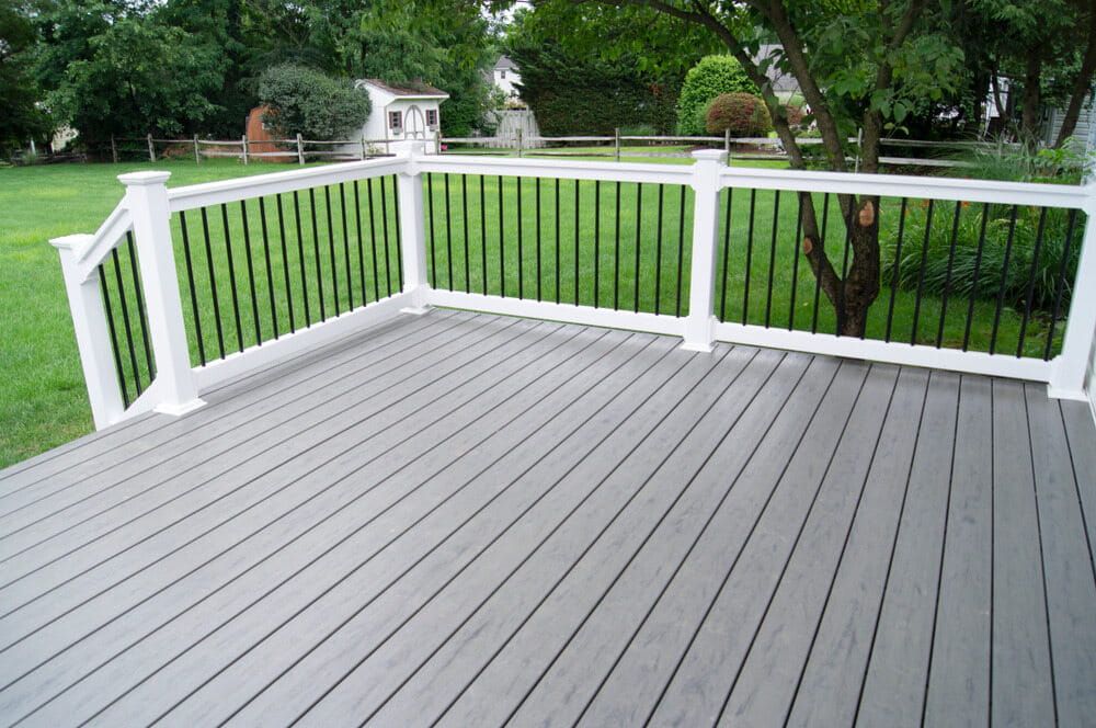 A Gray Deck With a White Railing and a Tree in the Background — Better Built Patios & Decking in Tweed Heads, NSW