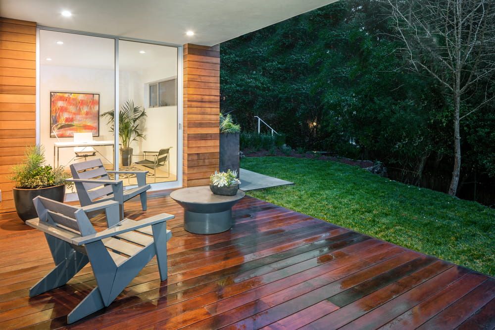A Wooden Deck With Chairs and a Table in Front of a House — Better Built Patios & Decking in Lennox Head, NSW