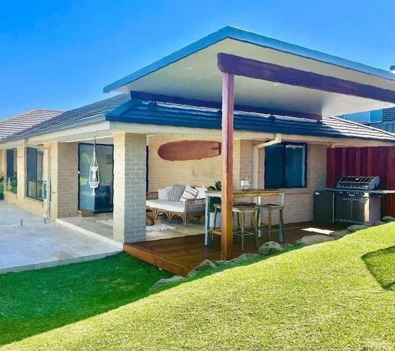 A House With a Covered Patio and a Surfboard on the Roof — Better Built Patios & Decking in Wollongbar, NSW