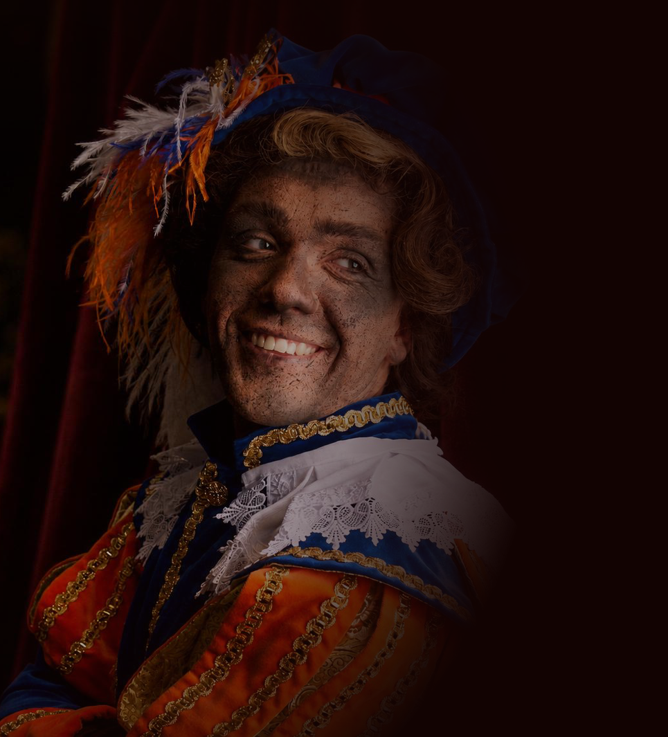 Persoon in een sierlijk oranje en blauw kostuum, lachend tegen een donkere achtergrond.