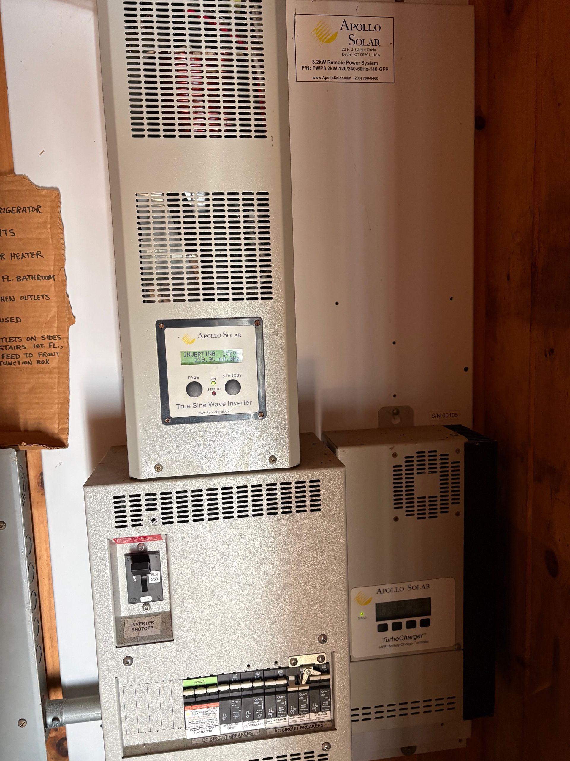 Wall-mounted electrical control panels and breakers in a utility room with beige cabinets and switches