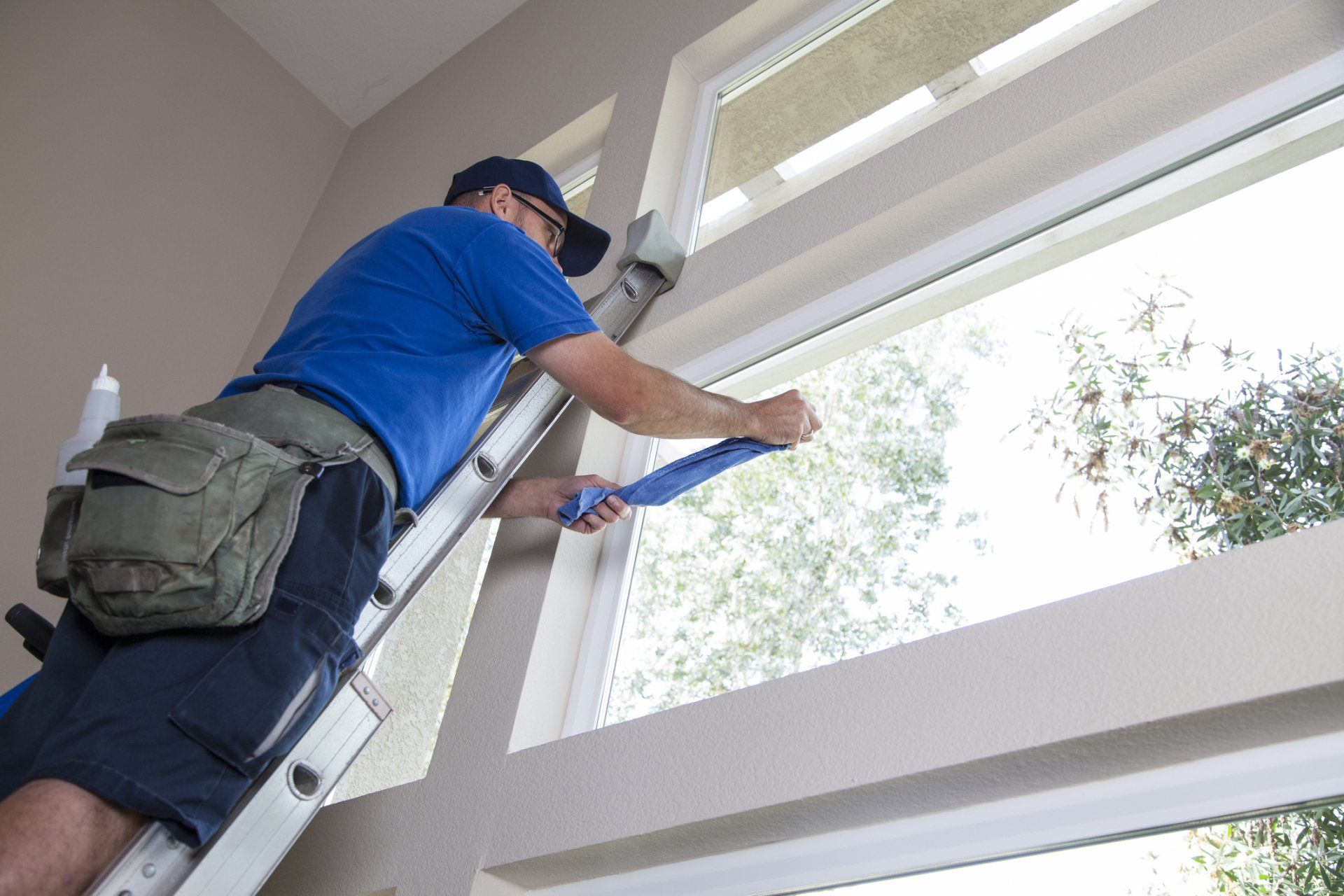 Man Cleaning Window of A Home – Fargo, ND - Automated Maintenance Services, Inc.