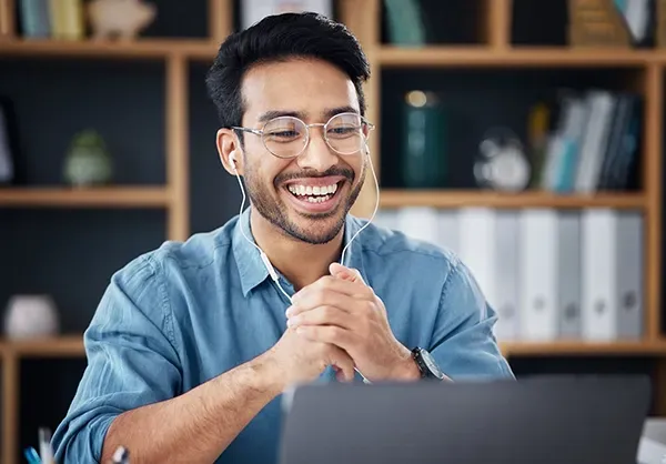 Person participating in an online meeting or virtual training session using a laptop and headset.