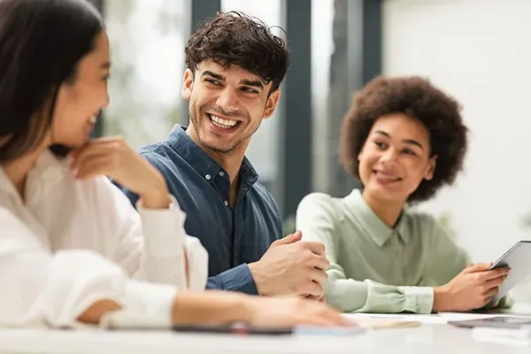 Group of professionals engaged in a collaborative discussion around a meeting table in a modern office.