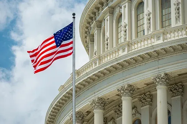 American flag flying in front of the United States Capitol building in Washington, D.C.