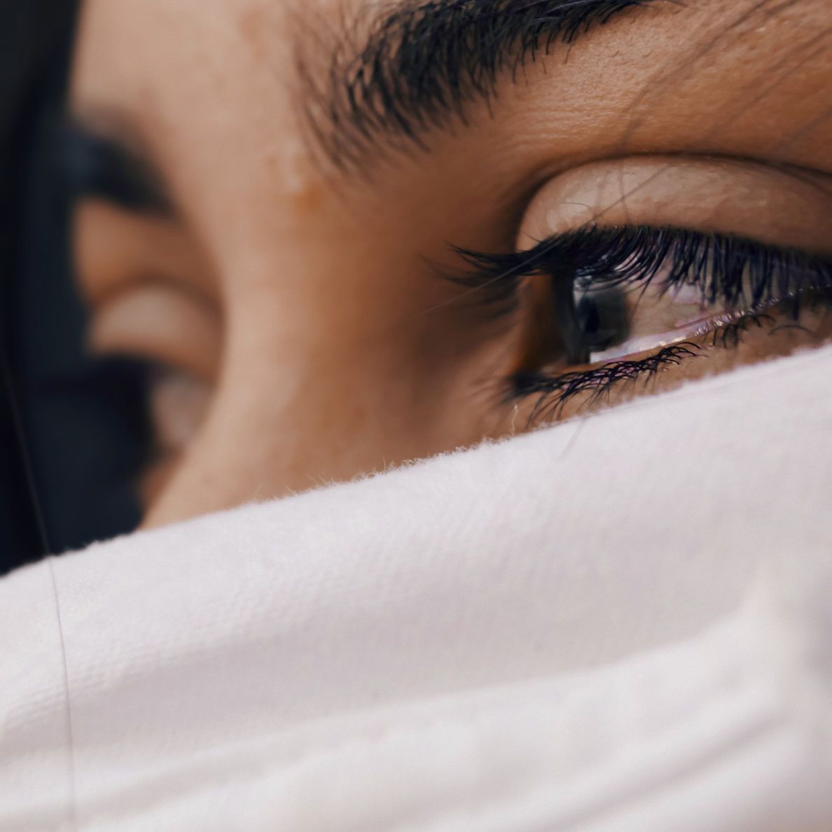 Close-up of eyes peering over a white face covering