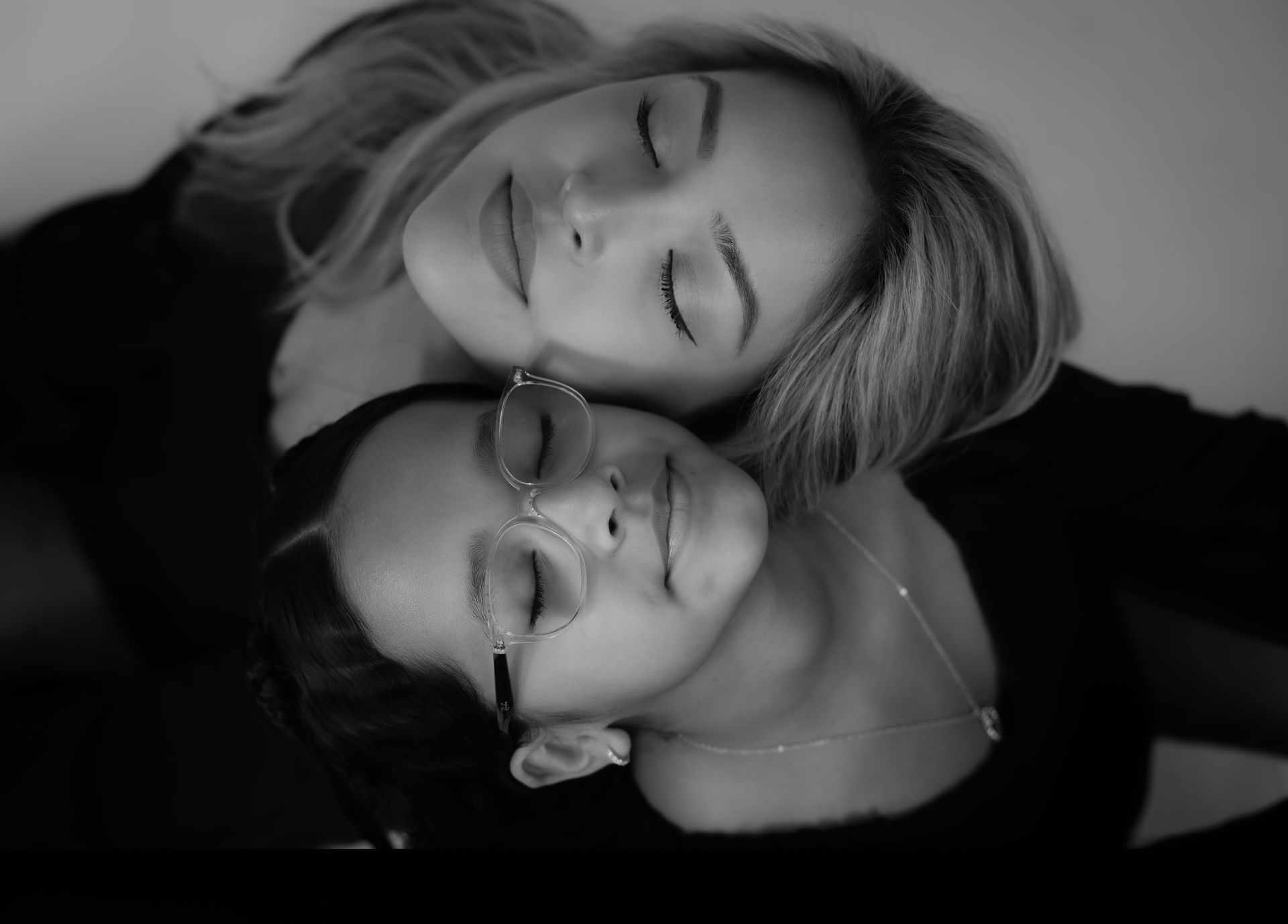 Two people, eyes closed, faces touching, in a close embrace. Black and white.