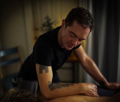 Therapist holding a patient’s foot during a treatment session in a clinical room