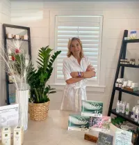 Woman standing in a bright boutique with shelves of candles and packaged goods