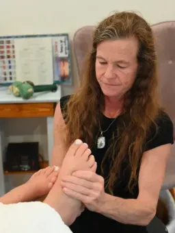Therapist holding a patient’s foot during a treatment session in a clinical room