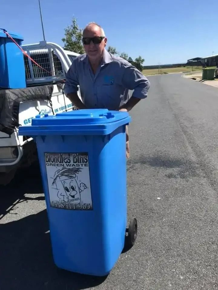 Man Standing Next to Blue Trash Bin Labelled — Blondies Bins in Andergrove, QLD