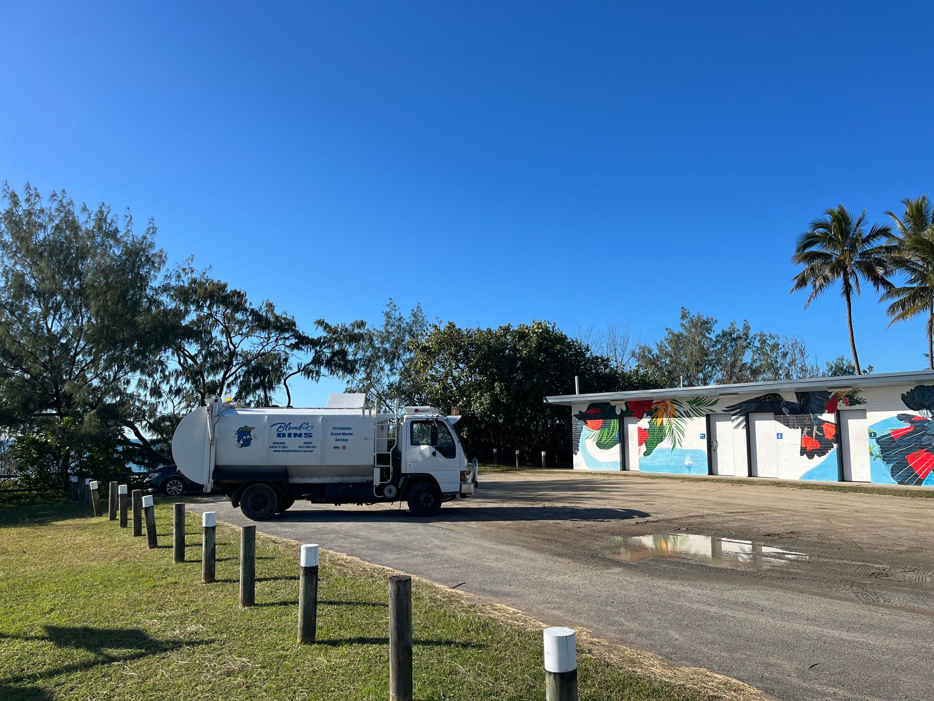 White Sanitation Truck on a Dirt Road by Painted Restrooms — Blondies Bins in Sarina, QLD