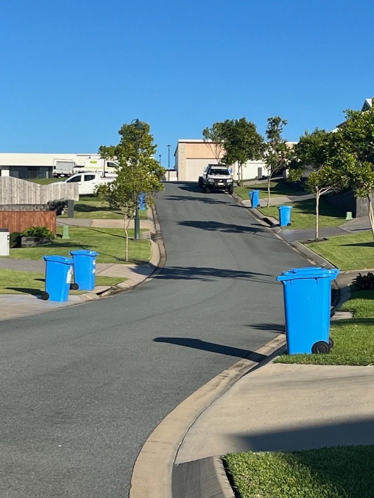 Three Bags Of Leaves Are Sitting On Top Of A Lush Green Lawn — Blondies Bins in Sarina, QLD