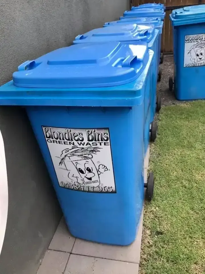 Blue Trash Bins Lined Up Against a Wall — Blondies Bins in Bucasia, QLD