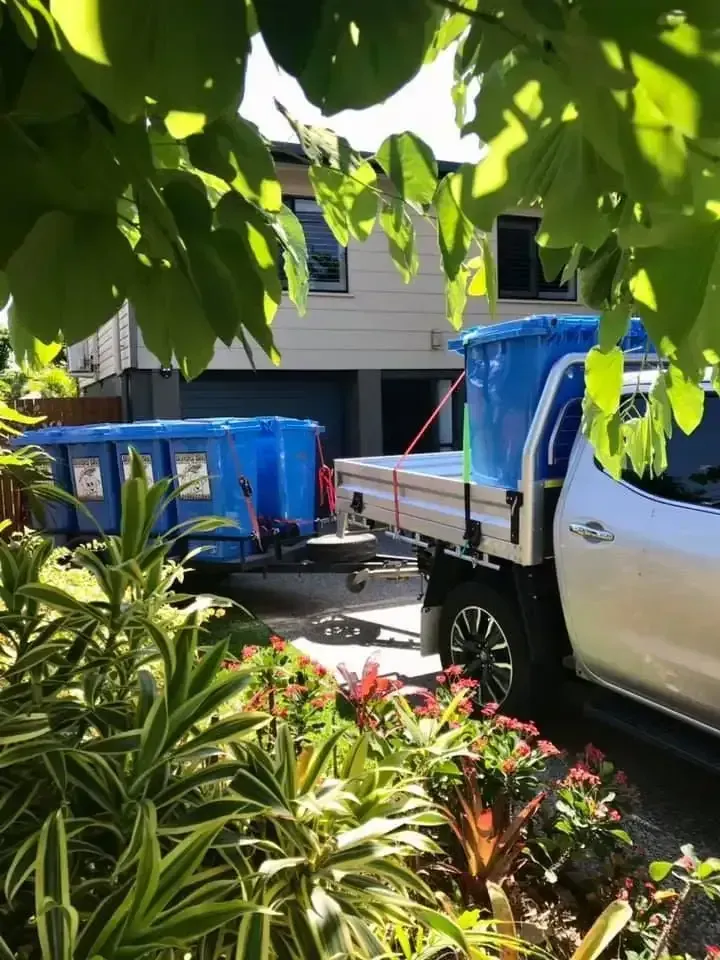 A Truck With a Trailer Carrying Large Blue Bins — Blondies Bins in Shoal Point, QLD