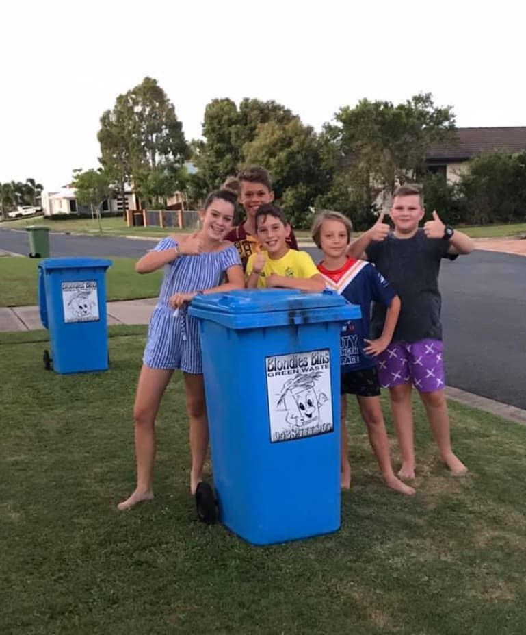 A Group Of Children Are Standing Around A Blue Garbage Can — Blondies Bins in East Mackay, QLD