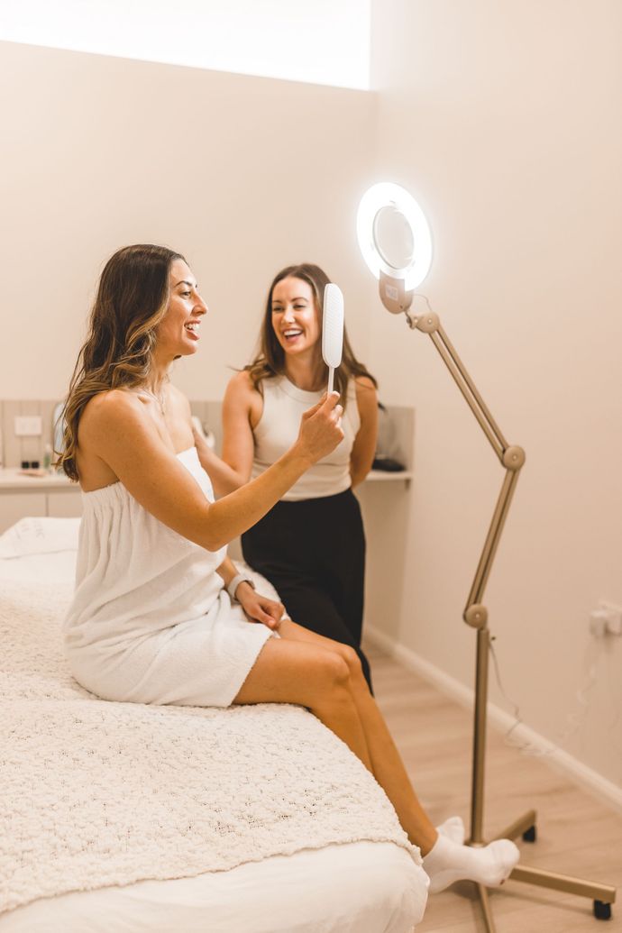 Tijan sharing a laugh with a client after a satisfactory treatment at Aesthetic Artistry Skin Clinic in Wollongong