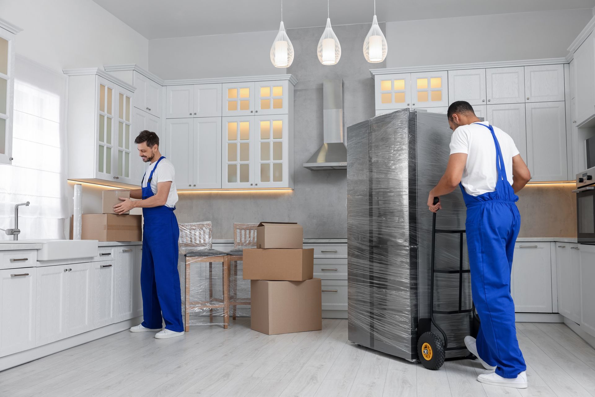 Two men are carrying boxes and a refrigerator. Two men are carrying boxes and a refrigerator.
