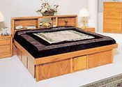 A wooden bed with drawers underneath it in a bedroom.