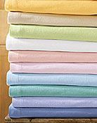 A stack of colorful towels sitting on top of each other on a wooden table.