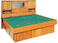 A wooden bed with a green table and drawers underneath it.