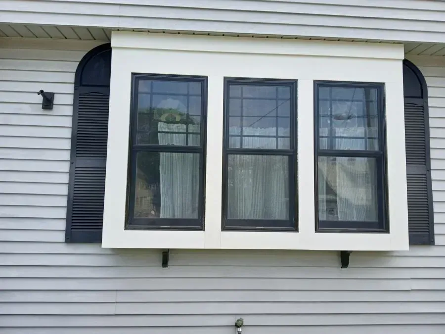 A house with a lot of windows and a wooden deck