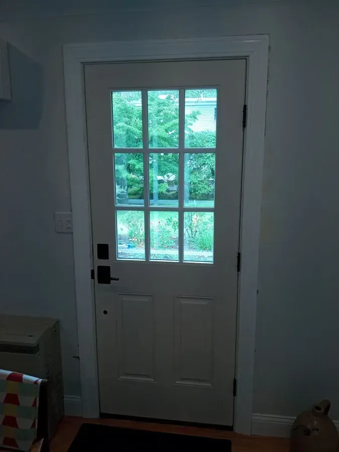 A white door with a window in a room.