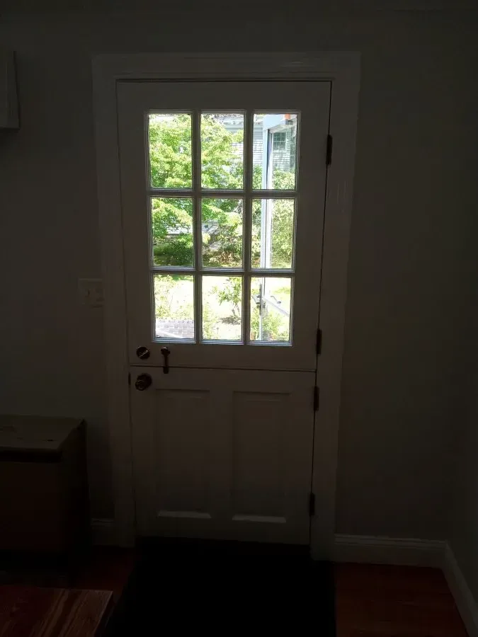 A white door in a room with a window