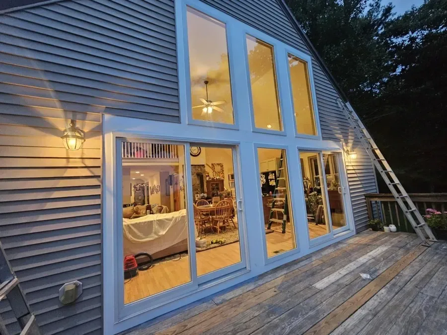 A house with a lot of windows and a wooden deck